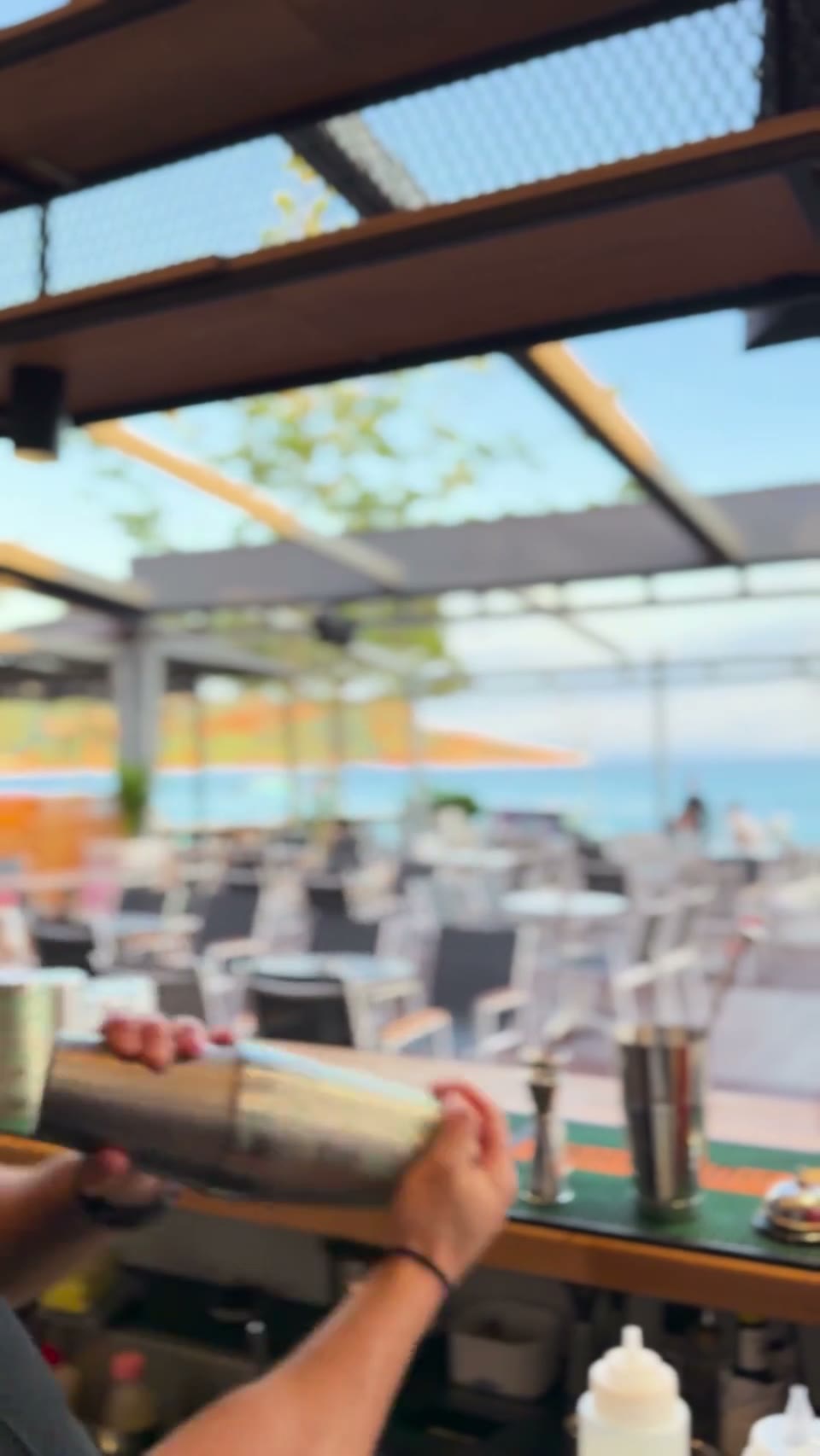 Bartender shaking a cocktail with sea view